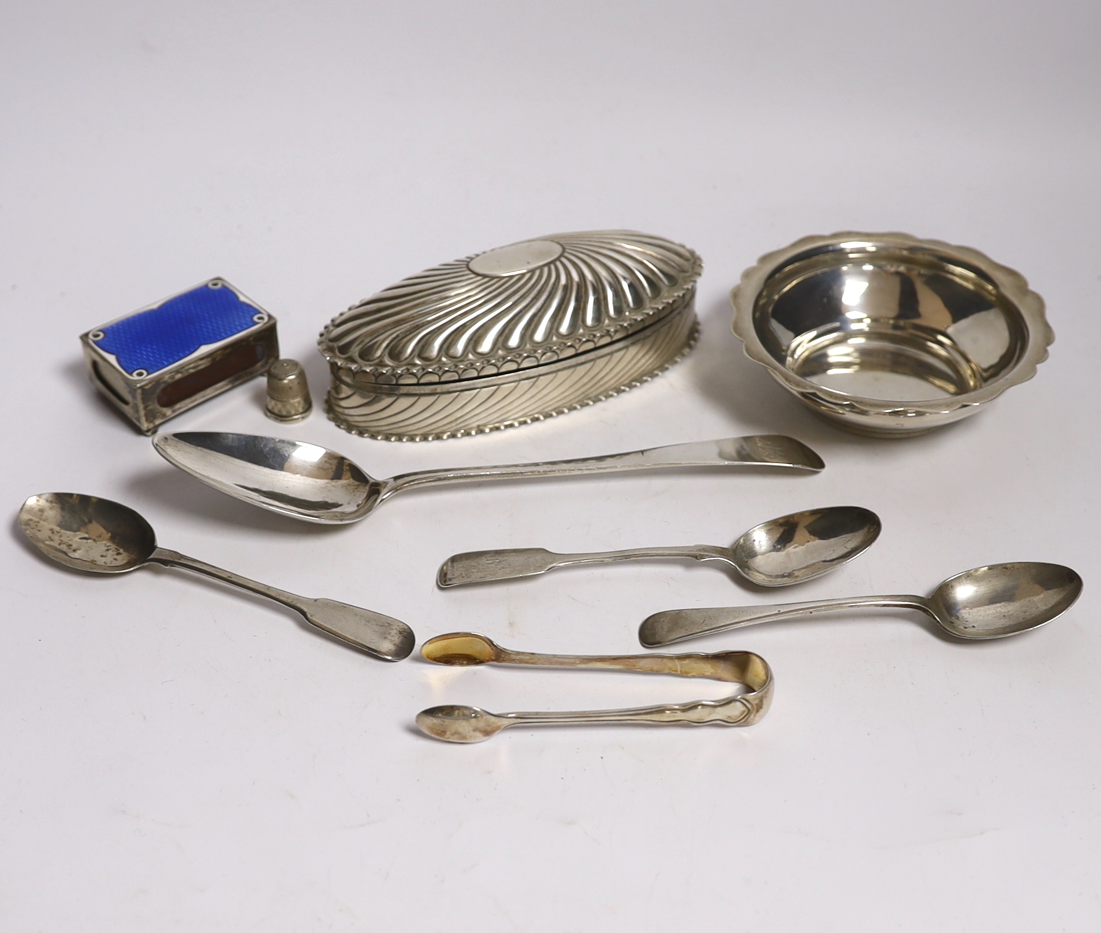 A late Victorian repousse silver oval trinket box by Horton & Allday, Birmingham, 1890, 15.2cm, together with five items of silver flatware, a silver bowl, silver and enamel matchbox sleeve and a sterling thimble.